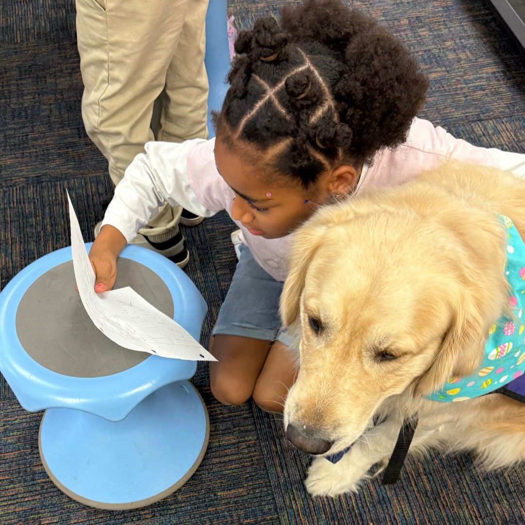 little girl reading to dog